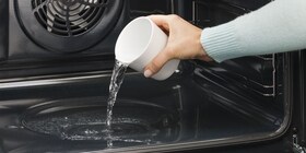 Uma pessoa a verter água para a cavidade do forno