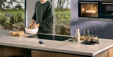 Mãos na tigela e Google Assistant na bancada